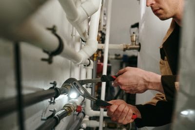 Technician inspecting commercial plumbing pipes in Cupertino