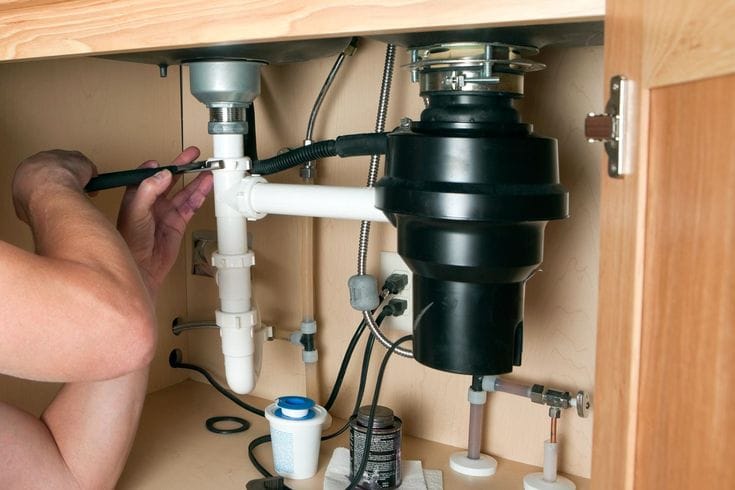 Plumber repairing a garbage disposal in Cupertino